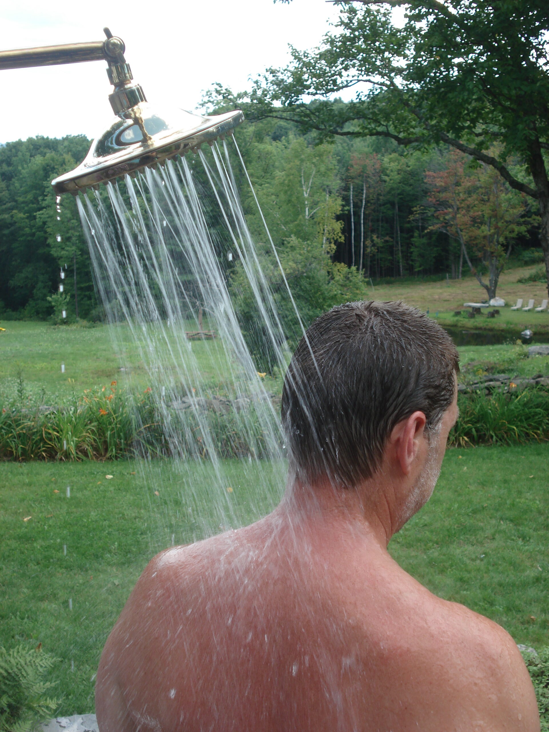 Man rinsing off in an outdoor shower.
